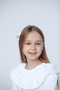 A beautiful cheerful little girl about 10 years old in a beautiful dress on an isolated white background.A place for your text.