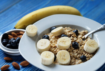 Healthy breakfast, food and diet concept - oatmeal with fresh berries on white plate with orange juice and milk