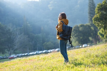 Portrait image of a female traveler with backpack while traveling on mountains