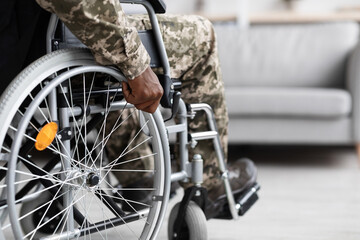 Unrecognizable black soldier sitting in wheelchair, copy space