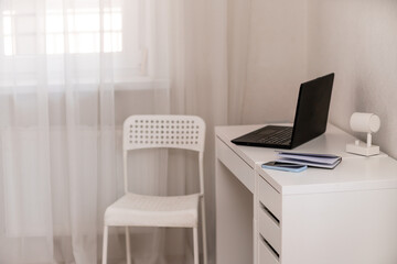 White desktop with laptop for remote work or study. Office computer workplace in home interior