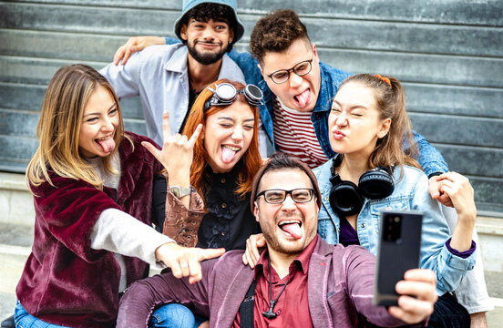 Multicultural best friends taking selfie out side at urban location - Happy millenial life style concept with young people students having fun together - Cold vivid filtered look
