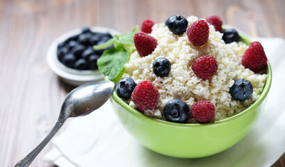 healthy breakfast cottage cheese with berries over wooden background, flat lay