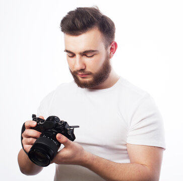 Lifestyle, fashion and people concept: young bearded man wearing white t-shirt with a digital camera