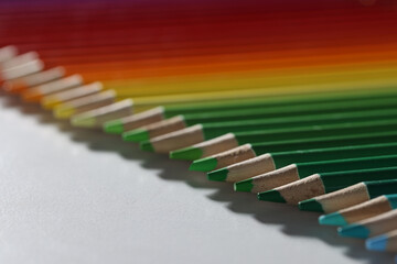 Colored pencils lie in a row on the table, blurry