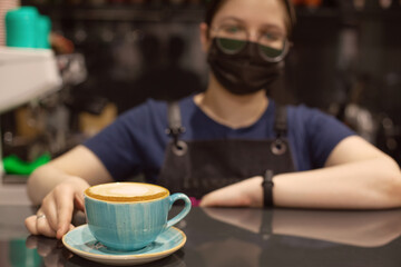 Barista serves a cup of coffee for a client