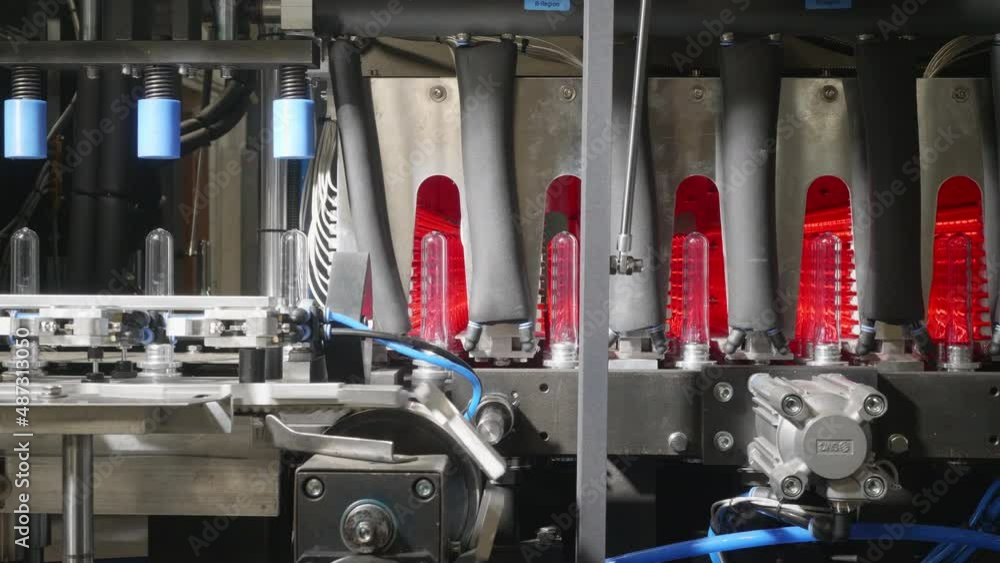 Poster elements of a robotized production line are moving transparent pet preforms