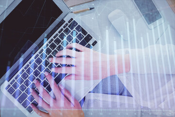 Double exposure of woman hands working on computer and forex chart hologram drawing. Top View. Financial analysis concept.