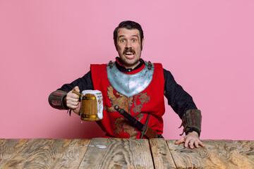 Portrait of medieval warrior or knight with dirty wounded face holding huge mug of beer isolated...