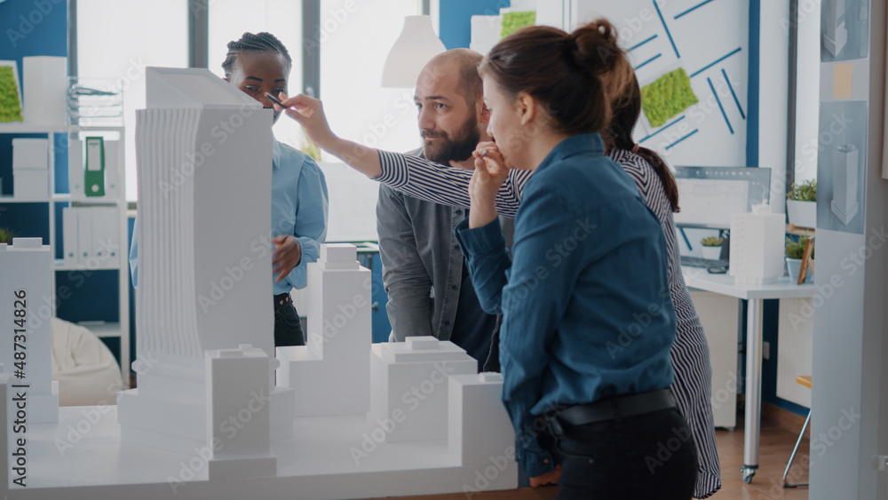 Poster multi ethnic people working with building model to design urban architectural project. architects co