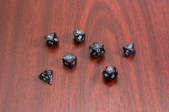 Specialized polyhedral dice for role-playing games on red wooden table