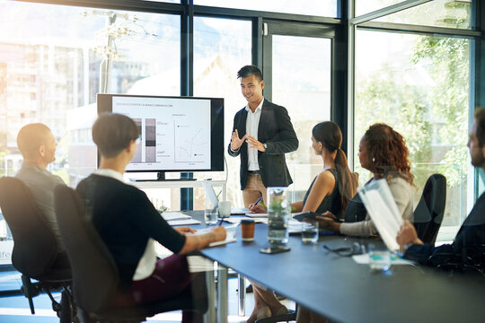 Presenting his ideas to the table. Shot of a group of businesspeople meeting in the boardroom.