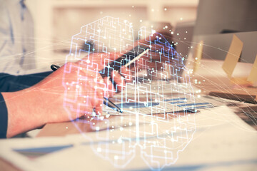 Double exposure of man's hand holding and using a digital device and brain hologram drawing. Data...