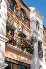 Façade of Andalusian house in Nerja , costa del Sol , Malaga. Flower in balcony, Andalusian architecture, typically white houses ,with stone décor and flowers in the balcony. 