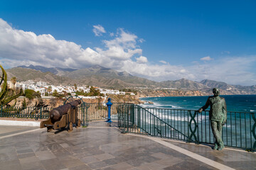View from Balcony of Europe in Nerja, Malaga. Statue of King Alfonso XII. Old wooden Cannon. Sierra...