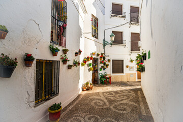 Beautiful streets of Nerja city - Malaga - Spain. Typically Andalusian village with white houses and small streets. Touristic travel destination ln Costa del Sol. Flower pot on the wall. Winter time