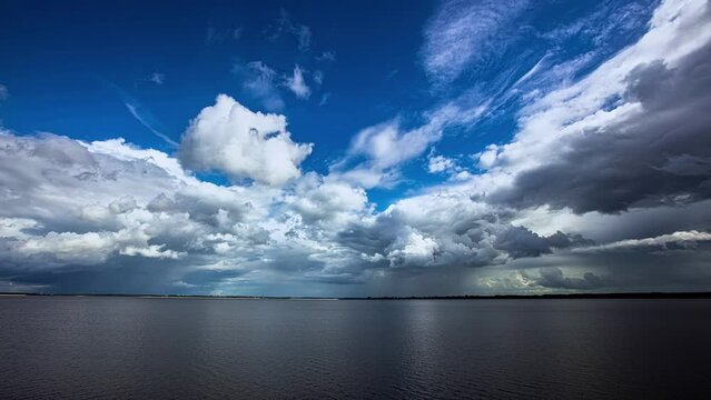 Timelapse shot over the huge reservoir with white clouds moving swiftly in Latvia near city of Salaspils and Riga. Overview of a huge reservoir holding the water of the Daugava river on a cloudy day.