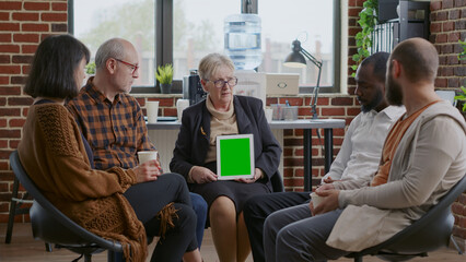 Psychotherapist and patients looking at green screen on digital tablet, attending aa meeting. Woman therapist holding mockup template and isolated background on chroma key device