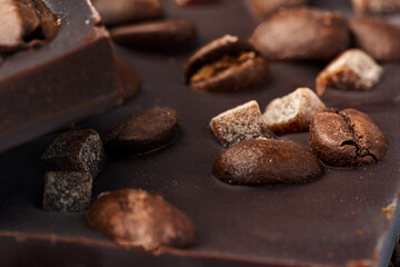 Close up of dark chocolate bar with coffee beans and candied fruit