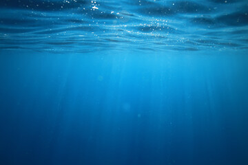 Obraz premium ocean underwater rays of light background, under blue water sunlight