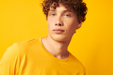Obraz premium guy with red curly hair Youth style glasses studio casual wear yellow background unaltered