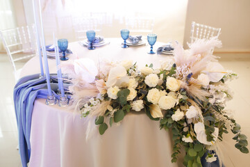 banquet table is decorated with plates, cutlery, glasses, candles and flower arrangements