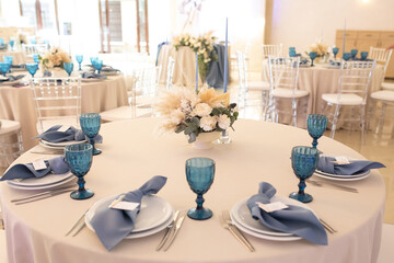 banquet table is decorated with plates, cutlery, glasses, candles and flower arrangements