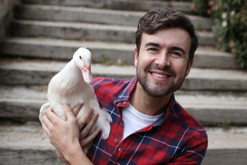 Man holding a beautiful white duck 