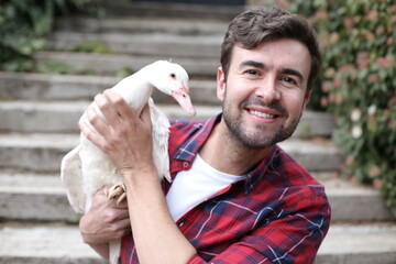 Man holding a beautiful white duck