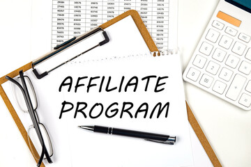 Text AFFILIATE PROGRAM on the white paper on clipboard with chart and calculator
