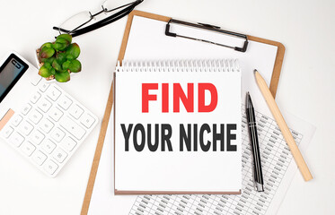 Office desk table with paper sheet, notepad ,chart and calculator. Top view, text FIND YOUR NICHE