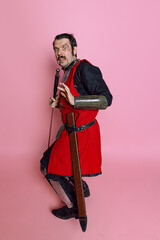 Full-length portrait of scary man, medieval warrior or knight in armor clothing, red costume...