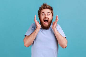 Portrait of pleasantly surprised glad bearded man smiles broadly shocked to receive unexpected...
