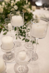 banquet table is decorated with plates, cutlery, glasses, candles and flower arrangements