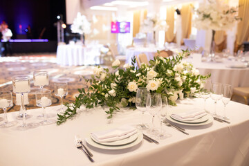 banquet table is decorated with plates, cutlery, glasses, candles and flower arrangements