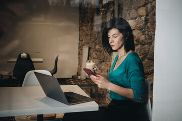 Fototapeta na wymiar Businesswoman with laptop in cafe