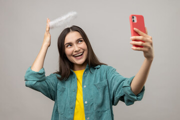 Portrait of woman blogger with nimb over head, broadcasting livestream, showing her halo to...