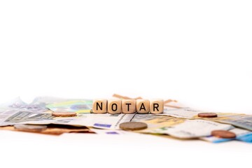 German word for Notary, NOTAR, spelled with wooden letters wooden cube on a plain white background...