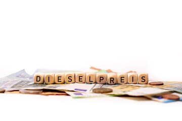 German word for diesel price, DIESEL PREIS, spelled with wooden letters wooden cube on a plain...