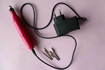 Set of manicure tools for hardware manicure on a pink background. Hardware manicure. Nail care .