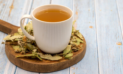 Winter herbal tea on a blue wood background. Winter tea. immune-boosting herbal tea. Medicinal tea prepared from linden leaves, Clove particles and Chamomile