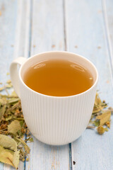 Herbal tea on a blue wood background. linden tea. immune-boosting herbal tea. Medicinal tea prepared from linden leaves, Clove particles and Chamomile