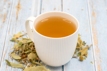 Herbal tea on a blue wood background. linden tea. immune-boosting herbal tea. Medicinal tea prepared from linden leaves, Clove particles and Chamomile