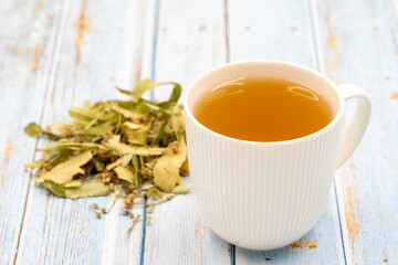 Herbal tea on a blue wood background. linden tea. immune-boosting herbal tea. Medicinal tea prepared from linden leaves, Clove particles and Chamomile