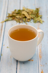 Herbal tea on a blue wood background. linden tea. immune-boosting herbal tea. Medicinal tea prepared from linden leaves, Clove particles and Chamomile