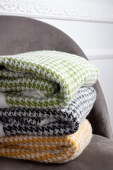Stack of clothes in a houndstooth ornament on a gray chair, closeup.