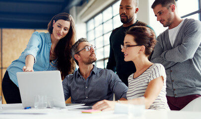Lets get everyones input on this. Shot of a group of coworkers having a meeting in an open plan...