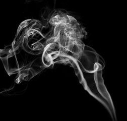Twisted plumes of smoke, smoke movement on a black background. Abstract smoke lines