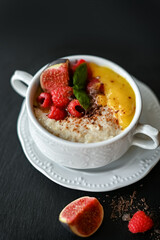 Breakfast oat porridge with berries and mango jam