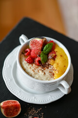 Breakfast oat porridge with berries and mango jam